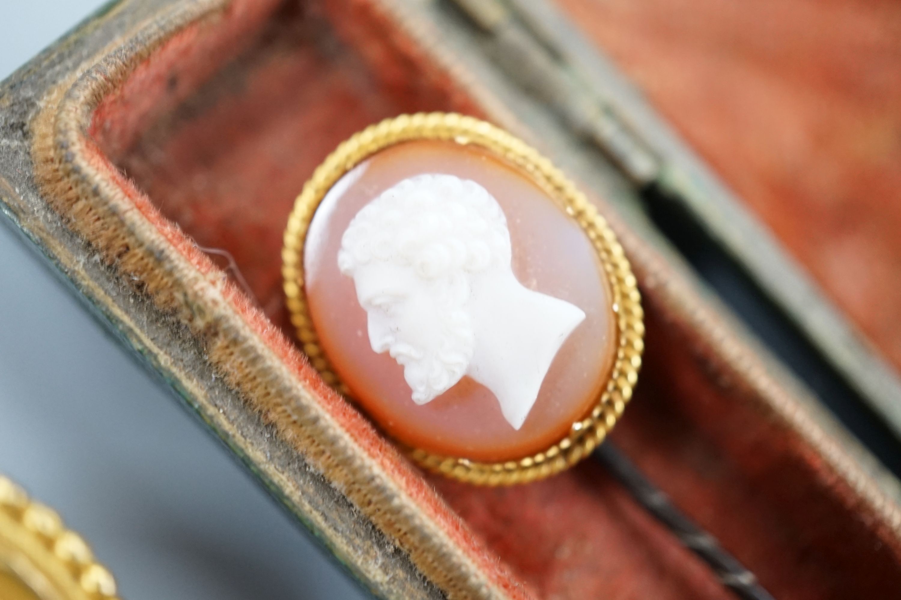 A Victorian yellow metal and cabochon garnet set circular brooch, 31mm, gross 9.3 grams, a stick pin with yellow metal and hardstone cameo set terminal, a mounted Indian miniature, a mounted cameo shell brooch and a Vict